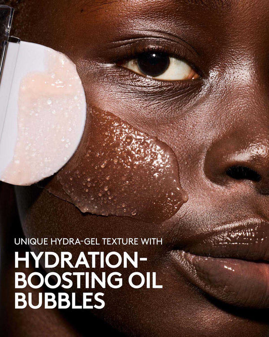 Close-up of a person's face with skincare product application, highlighting hydration-boosting oil bubbles.