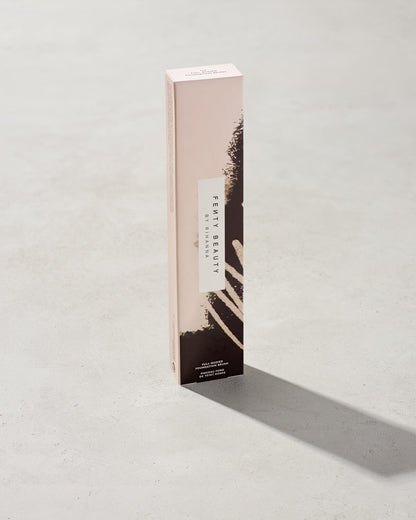 Packaging of the Full-Bodied Foundation Brush 110, featuring pink and black designs, standing upright on a concrete backdrop.