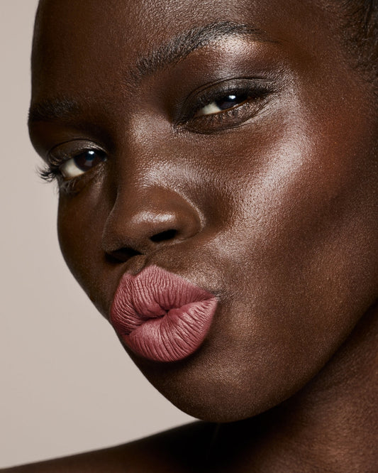 deep skin toned model wearing stunna lip paint in the shade uncuffed