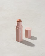 Match Stix Shimmer Skinstick shown in shade Sinamon on a concrete background.