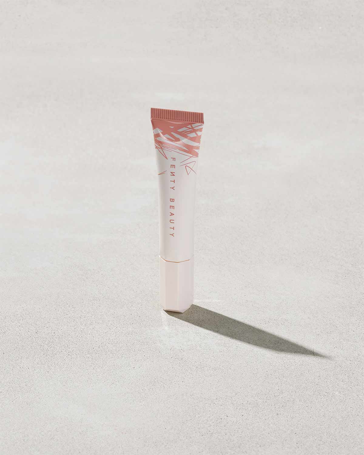 Closed Tube of Pro Kiss'r Luscious Lip Balm in shade Latte Lips on grey background.