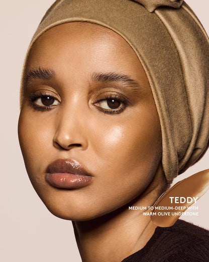 Medium to Medium-deep skin tone model wearing cheeks out bronzer in shade teddy.