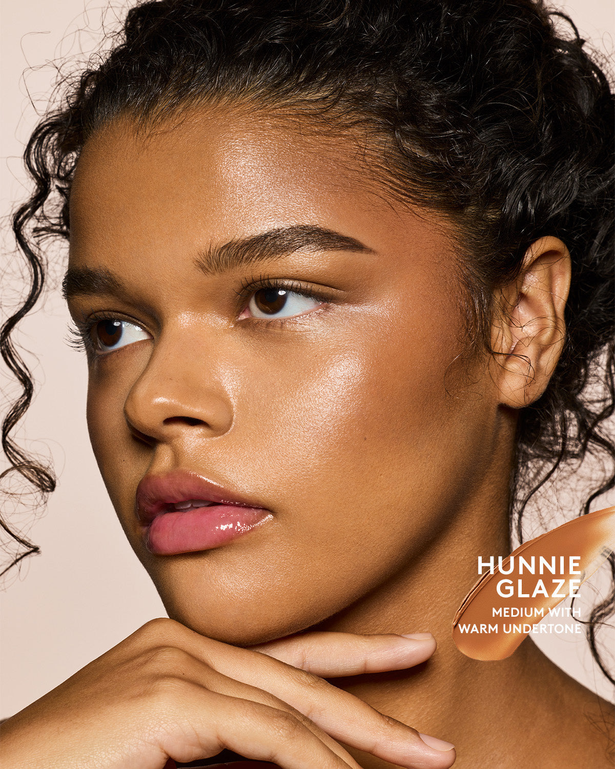 Medium skin tone model wearing cheeks out bronzer in shade Hunnie Glaze.