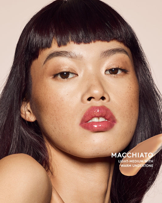 Light-medium skin tone model wearing cheeks out bronzer in shade Macchiato.