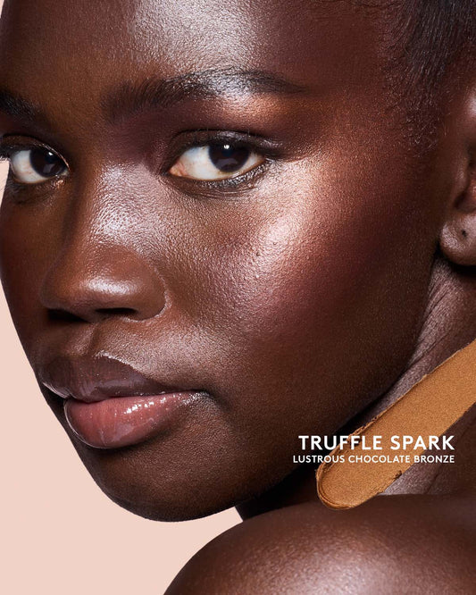 Deep skin toned model wearing match stix shimmer in shade Truffle Spark.
