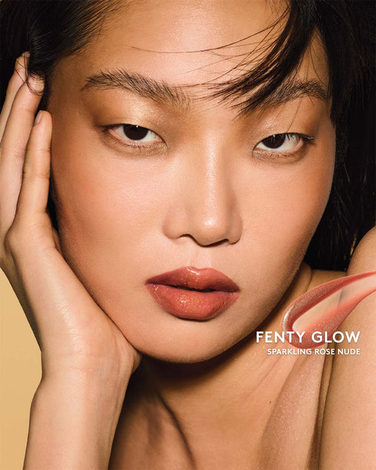 Gloss Bomb Oil Luminizing Oil and Gloss in shade Fenty Glow on a light skin tone. Fenty Glow is a sparkling rose nude.