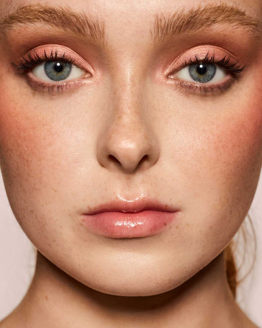 light skin toned model wearing gloss bomb universal lip luminizer in candy soda