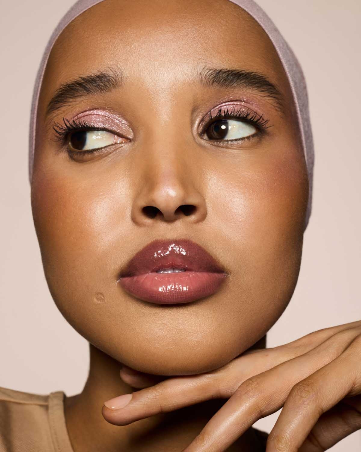 medium skin toned model wearing gloss bomb cream in shade fenty glow