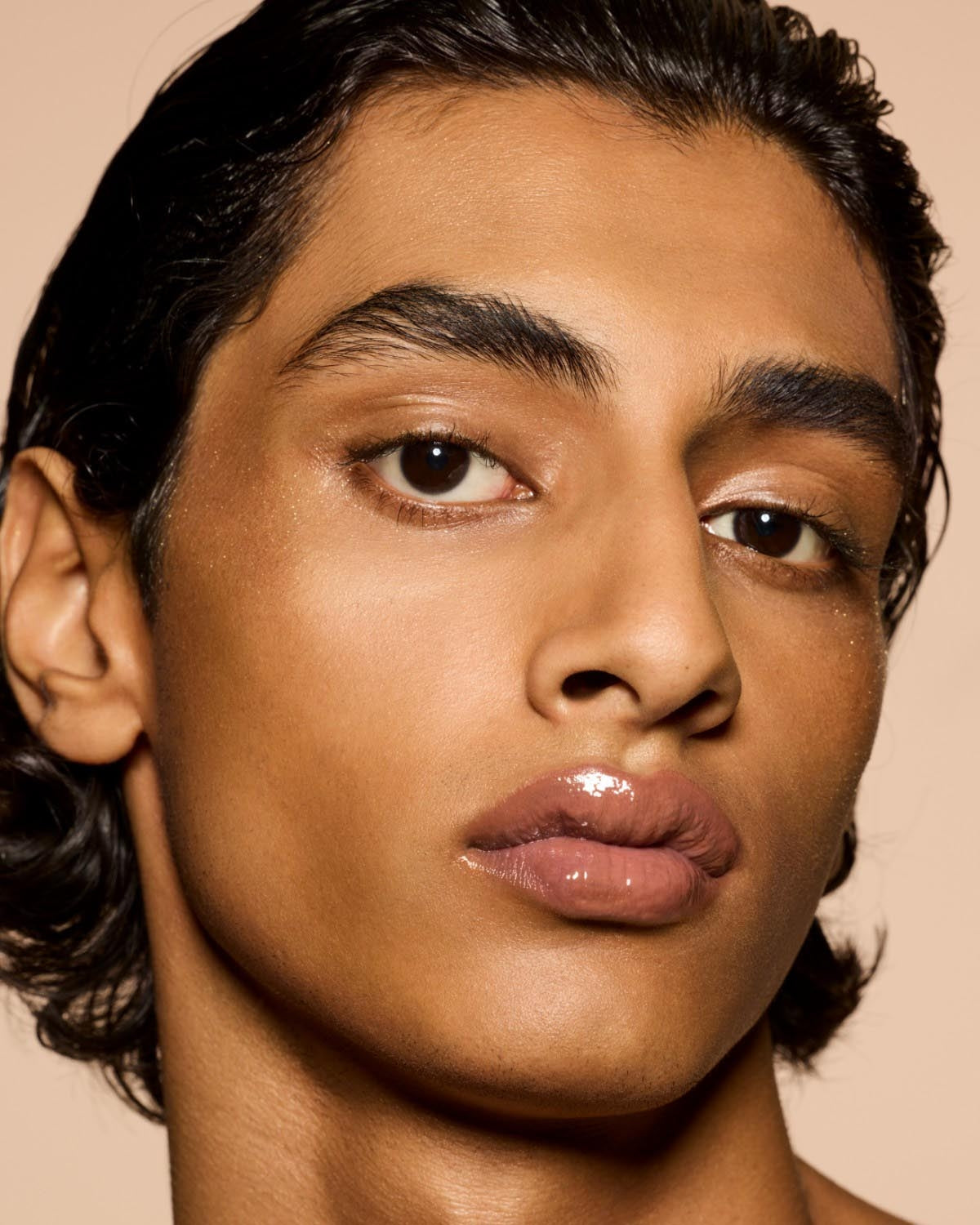 medium skin tone model wearing Gloss Bomb Heat Universal Lip Luminizer + Plumper in shade Fenty Glow Heat