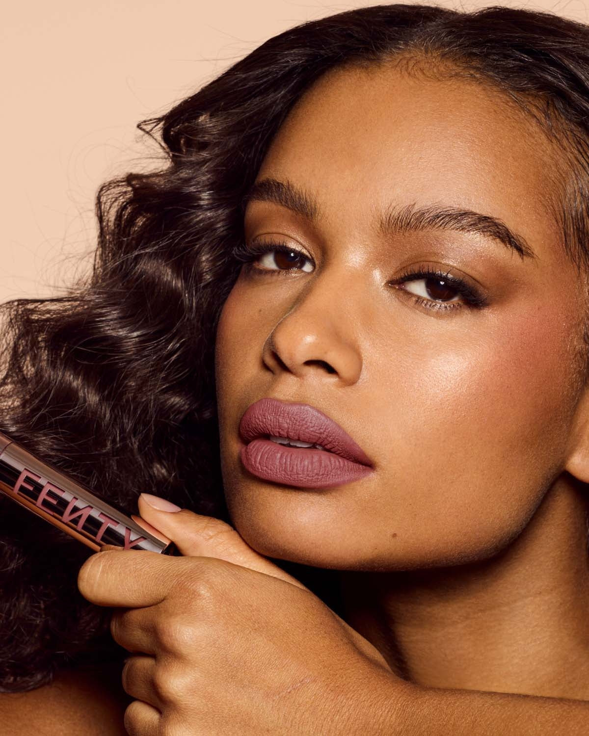 medium skin toned model wearing icon velvet longwear liquid lipstick in shade riri
