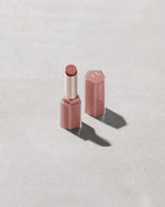Open product shot of Gloss Bomb Stix in shade Blazed Donut on a concrete background.