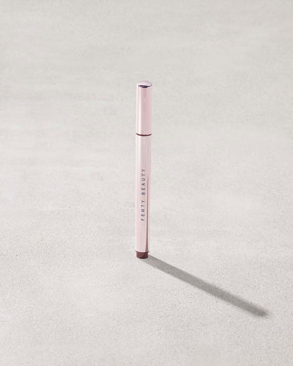 Fenty Beauty Flyliner Longwear Liquid Eyeliner in shade In Big Truffle on concrete background