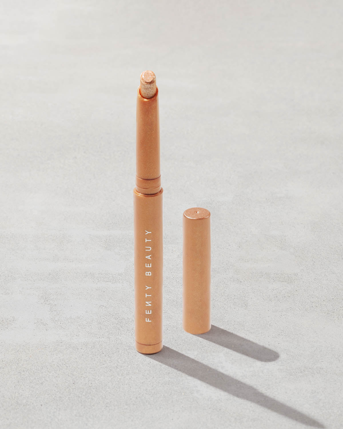 Open shot of Shadowstix Diamonds Diamond Veil Eyeshadow Stick in shade Champion on a concrete background.
