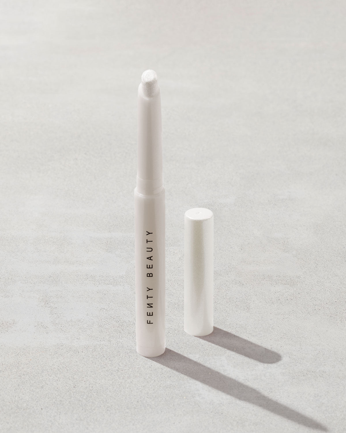 Open shot of Shadowstix Diamonds Diamond Veil Eyeshadow Stick in shade How Many Carats?! on a concrete background.