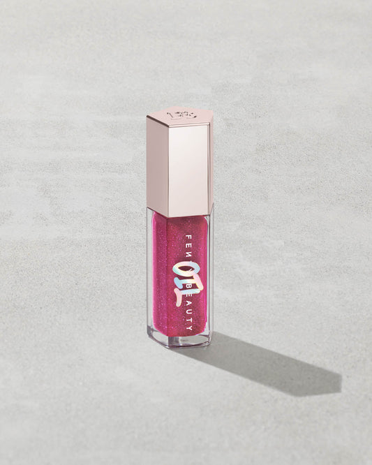 Gloss Bomb Oil Luminizing Oil and Gloss in shade Raspberry Jams product against a concrete background.