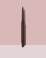 Fine Linez Lash Line-Enhancing Eyeliner in shade 'In Big Truffle' open capped product shot on a two-tone pink background.