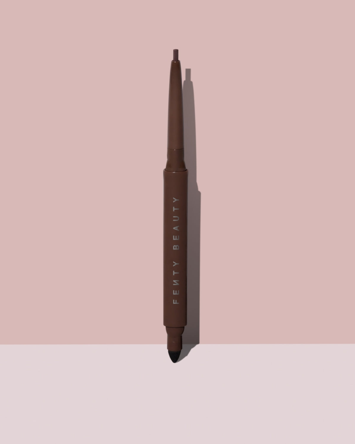 Fine Linez Lash Line-Enhancing Eyeliner in shade 'In Big Truffle' open capped product shot on a two-tone pink background.