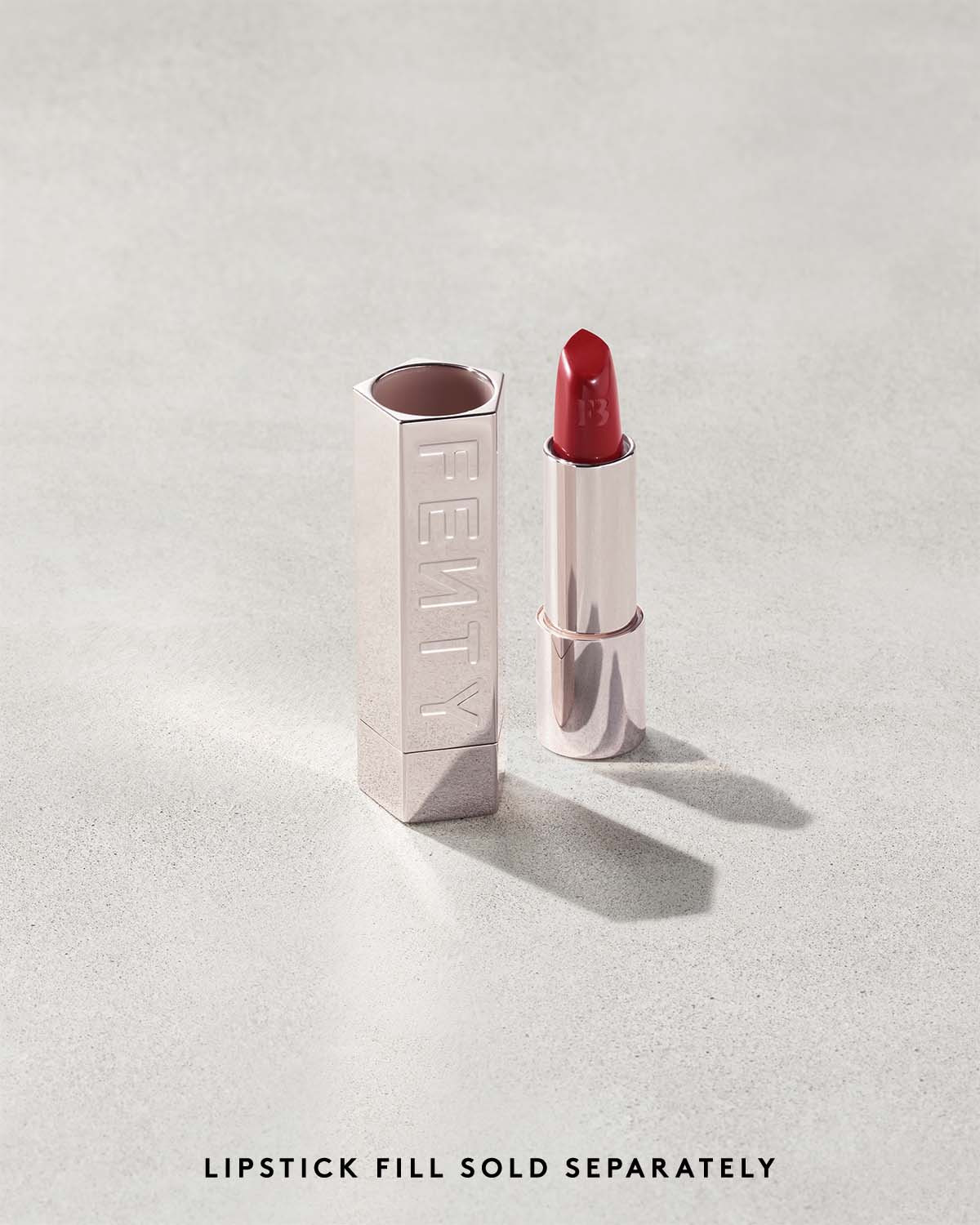 Fenty Icon lipstick shade in The MVP, next to a metallic lipstick case.