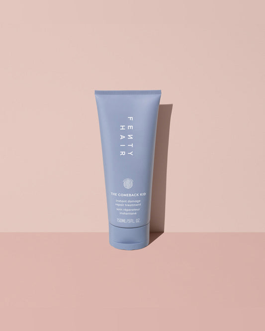 Fenty Hair The Comeback Kid Instant Damage Repair Hair Treatment Bond Builder tube made of 50% post-consumer recycled plastic on a pink background.