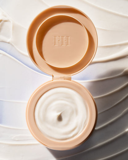 Open container of The Homecurl Curl-Defining Cream with a smear of the product underneath.
