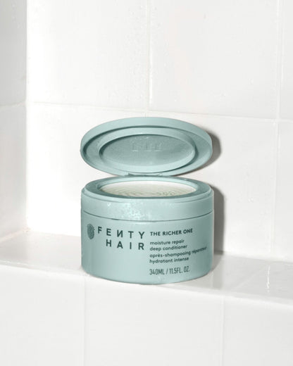 Fenty Hair The Richer One Moisture Repair Deep Conditioner tub made of 50% post-consumer recycled plastic in the shower.