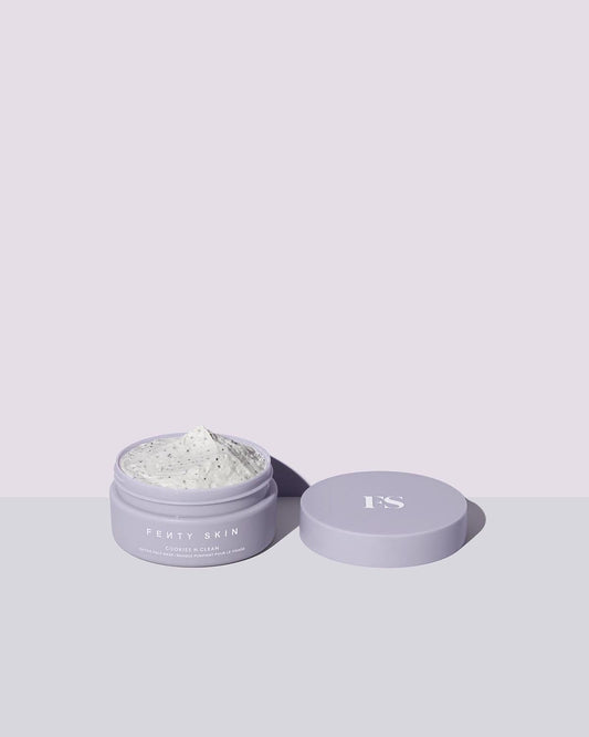 Open container of Cookies N Clean Clay Face Mask on a lilac background.