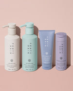 Fenty Hair shampoo next to conditioner, hair damage repair treatment, and 5-in-1 heat protectant hair styler.